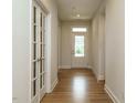 Hallway with hardwood floors, a view of the front door, and interior French doors to another room at 660 Still Willow Ln, Wendell, NC 27591