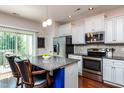Modern kitchen with granite countertops, stainless steel appliances, and a center island with bar seating at 7809 Lillyhurst Dr, Raleigh, NC 27612
