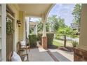 Charming covered porch with neutral furniture and beautiful brick accents at 808 Historian St, Raleigh, NC 27603