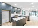 Bright, open kitchen featuring dark blue cabinets, white countertops, and stainless steel appliances, open to living area at 810 Culpepper Ln, Raleigh, NC 27610
