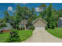 Inviting home with a well-maintained lawn, mature trees, and a spacious driveway leading to an attached garage at 90 Weatherly Dr, Franklinton, NC 27525