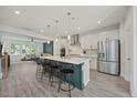 Bright, modern kitchen with a large island and stainless steel appliances opens to a cozy living area at 907 Lake Beacon Way, Raleigh, NC 27606