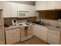 Functional kitchen featuring white cabinets, appliances, and ample counter space at 929 Morreene Rd # B-24, Durham, NC 27705