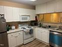 Kitchen featuring white cabinets, appliances and laminate countertop at 929 Morreene Rd # C-14, Durham, NC 27705