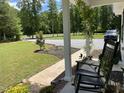 Relaxing front porch view with a rocking chair, overlooking a well-kept lawn and driveway at 956 W Greensboro Chapel Hill Rd, Snow Camp, NC 27349