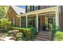 Charming front porch with brick steps, white columns, and lush landscaping at 1008 Old Meetinghouse Way, Raleigh, NC 27615
