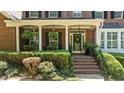 Inviting front porch with elegant columns, hanging plants, and a decorative front door at 1008 Old Meetinghouse Way, Raleigh, NC 27615