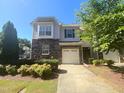 Inviting two-story townhome with stone accents, attached single car garage, and well maintained landscaping at 112 Salmon River Dr, Durham, NC 27705
