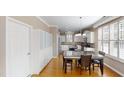 Bright kitchen with white cabinets, stainless appliances, large island and dining table area at 112 Salmon River Dr, Durham, NC 27705