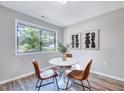 Charming dining area with wood-look floors, updated light fixture, and a large window at 1221 Teakwood Pl, Raleigh, NC 27606