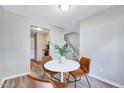 View of the dining area with seating for three, looking toward the updated kitchen and staircase at 1221 Teakwood Pl, Raleigh, NC 27606
