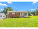 Charming single-story home with a brick facade and a well-maintained lawn and mature trees at 1315 Elder Way, Burlington, NC 27215
