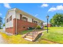 Charming single-story home with brick details, awning-covered windows and a manicured lawn at 1315 Elder Way, Burlington, NC 27215