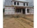 Unfinished home with brick and Hardie board awaiting completion with exposed 2x4 studs at 1327 Parkertown Rd, Four Oaks, NC 27524