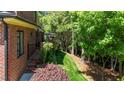 Exterior brick wall featuring a beautiful green lawn with mature trees at 145 Cofield Cir, Durham, NC 27707