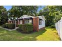Side angle showing the brick and siding detail of this cozy home with well-maintained landscaping at 163 Lake Latham Rd, Mebane, NC 27302