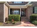 Inviting front porch with brick steps, tidy shrubs, and a decorated front door at 164 Avocet Ln, Clayton, NC 27520