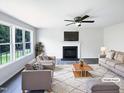 Staged living room features a fireplace, ceiling fan and ample natural light from large windows at 17 Ballard Ct, Durham, NC 27712