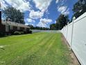 Spacious backyard with well-kept lawn and tall white fence, offering privacy and room for outdoor activities at 1828 Fletchers Chapel Rd, Durham, NC 27703