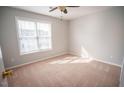 Bright bedroom with a ceiling fan and large window offering plenty of natural light at 19 Cheltenham Dr, Clayton, NC 27520