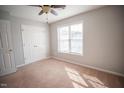A well-lit bedroom featuring a double door closet and neutral wall paint at 19 Cheltenham Dr, Clayton, NC 27520