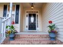 Inviting front entry featuring a black door with glass insert and decorative flower pots at 237 Water Front Ln, Timberlake, NC 27583