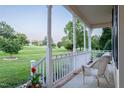 Relaxing porch with white wicker chair showcasing a serene outdoor view and beautiful lawn at 237 Water Front Ln, Timberlake, NC 27583