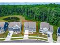 Aerial view of home on a verdant lot surrounded by mature trees and a serene pond at 2720 Spotted Coral Ct, Apex, NC 27502