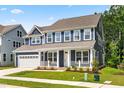 Charming two-story home featuring blue siding, a welcoming front porch, and a convenient attached two-car garage at 2720 Spotted Coral Ct, Apex, NC 27502