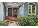 Inviting front porch with brick steps, and cozy seating, offering a welcoming entrance to the home at 311 Westbrook Dr, Carrboro, NC 27510