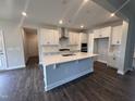 Modern kitchen with white cabinets, stainless steel appliances, quartz countertops and a large center island at 3509 Bailey Lake Dr, Fuquay Varina, NC 27526