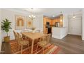 Light filled dining area with wood table, chairs, modern decor, and kitchen views at 501 Finsbury St # 204, Durham, NC 27703