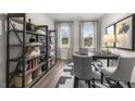 Well-lit office with shelving units and a desk with a laptop, illuminated by natural light from two windows at 541 Lemon Daisy Ln, Knightdale, NC 27545