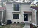 Neutral-toned two-story townhome featuring a small balcony and covered front entryway at 5805 Mapleridge Rd, Raleigh, NC 27609
