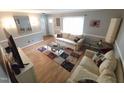 Comfortable living room with hardwood floors, neutral colors, and bright window lighting at 5805 Mapleridge Rd, Raleigh, NC 27609