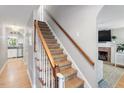 Traditional staircase featuring carpeted steps, a stained wood railing and trim, and neutral paint at 5908 Danville Dr, Raleigh, NC 27612