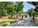 Wide view of the home's exterior, showcasing the fencing, driveway, and landscaping at 6005 Lake Wheeler Rd, Raleigh, NC 27603