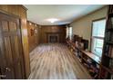 View of the living room with wood paneled walls, brick fireplace, and built-in bookshelves at 609 Sloan Dr, Cary, NC 27511