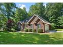 Attractive red brick home boasts a verdant lawn, tidy landscaping, and an attached two-car garage at 745 Oaks Lane Rd, Timberlake, NC 27583