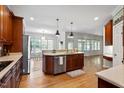 Open kitchen with island, stainless steel appliances, and hardwood floors at 7801 Kingsbrook Ct, Wake Forest, NC 27587