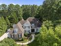 Stunning aerial view of a beautiful home surrounded by mature trees in a lush landscape at 8416 Davishire Dr, Raleigh, NC 27615