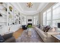 Elegant living room with custom built-ins, fireplace, hardwood floors, and tray ceiling at 8416 Davishire Dr, Raleigh, NC 27615