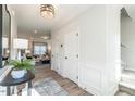 Hallway featuring wood floors, elegant trim, and a view into the brightly lit living room at 88 Freedom Heights Ln # 148, Smithfield, NC 27577
