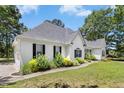 Side view of a white-sided home with black shutters, lush landscaping, and a well-manicured lawn, showcasing curb appeal at 904 Parkridge Dr, Clayton, NC 27527