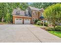 Two-story brick home with a two car garage, a blue door awning and landscaped front yard at 1030 W Sterlington Pl, Apex, NC 27502