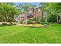 Beautiful brick home with lush front lawn and landscaped flower bed at 1030 W Sterlington Pl, Apex, NC 27502