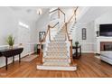 Grand foyer featuring a staircase with carpeted treads, hardwood floors, and a bright, open feel at 107 Quarter Path, Cary, NC 27518