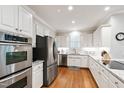 Well-lit kitchen with stainless steel appliances, granite countertops, and white cabinetry at 107 Quarter Path, Cary, NC 27518