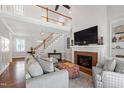 Spacious living room with a fireplace, hardwood floors, and an open staircase leading to the second floor at 107 Quarter Path, Cary, NC 27518