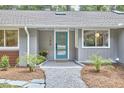 Close up of the front of the home showing the teal front door and newly landscaped yard at 108 Cedar St, Chapel Hill, NC 27514